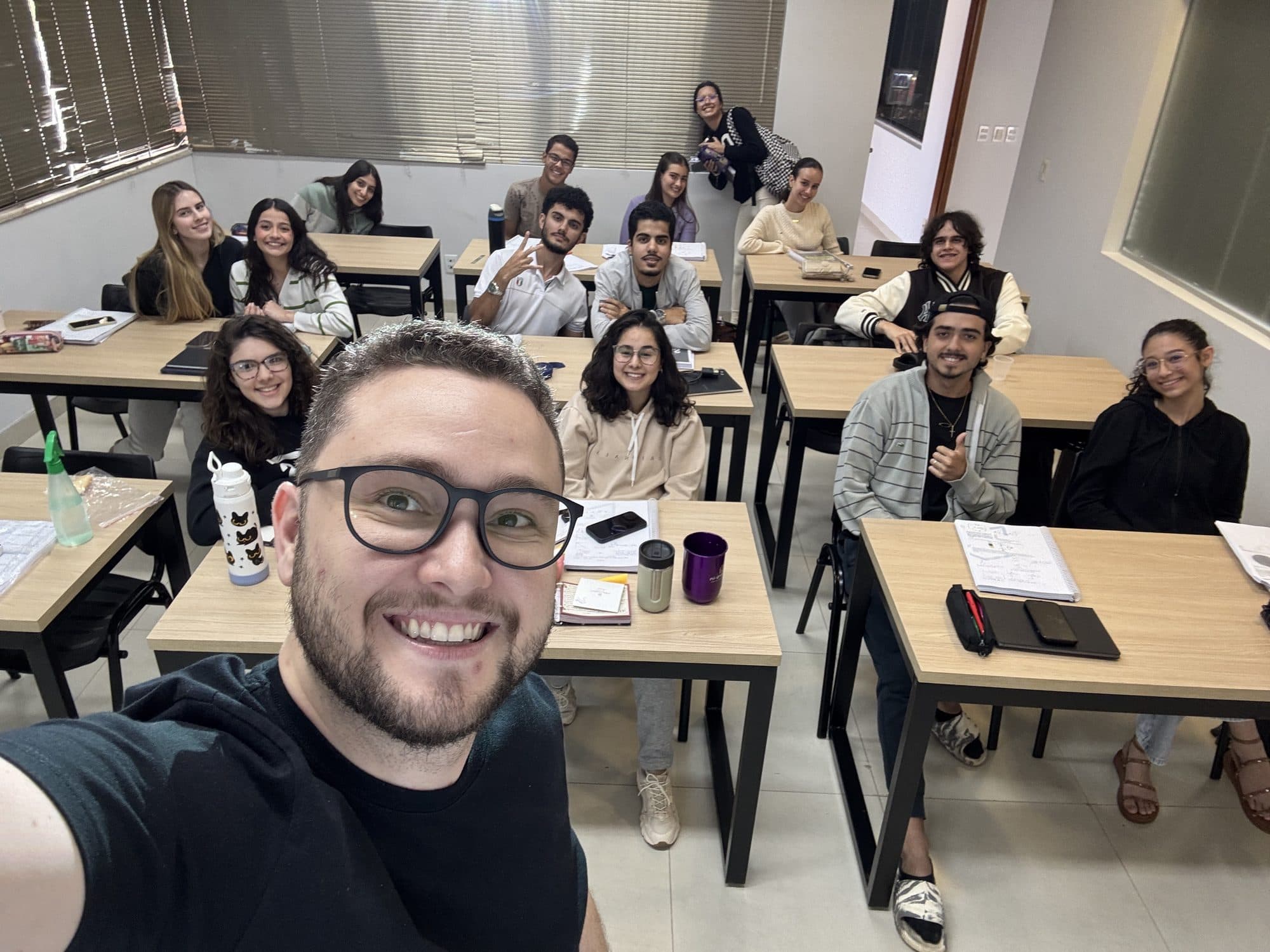 Turma do Aprova-in Educação sorrindo em grupo com o professor Gabriel